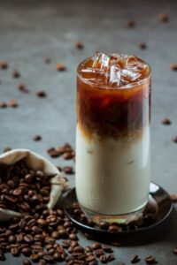 caffe-freddo-in-un-bicchiere-alto-con-crema-condita-con-caffe-freddo-decorato-con-chicchi-di-caffe_1150-22916